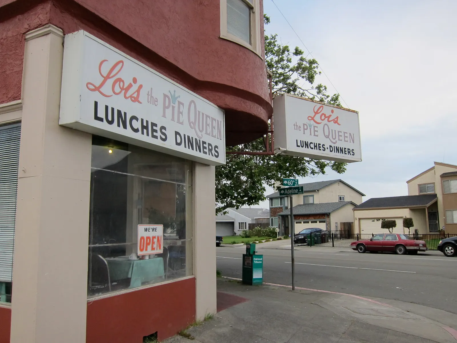 The corner storefront of Lois the Pie Queen with its red and white signs reading Lunches Dinners