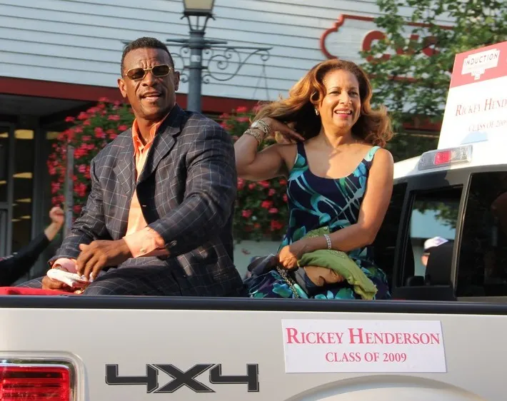 Rickey Henderson riding in the back of a parade truck with a sign reading Rickey Henderson, Class of 2009