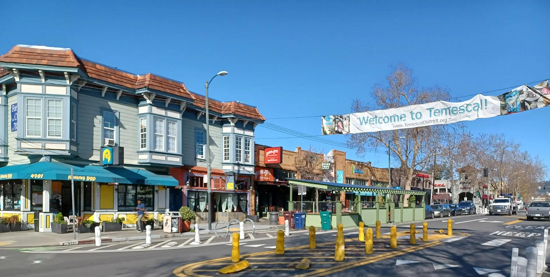 Shops along Telegraph Avenue under a Welcome to Temescal banner